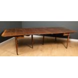 A George III mahogany concertina action drop leaf extending dining table with six turned supports