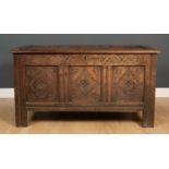 A late 17th / early 18th century oak triple panel coffer with carved decoration, 128cm wide x 54cm