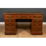 An Edwardian Maple & Co mahogany pedestal desk with a green leather inset top, seven drawers and
