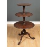 A George III mahogany dumb waiter with turned stem and triform base, 60cm diameter x 110cm high From