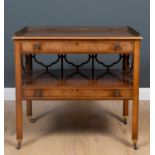 A yew wood two tiered side table the galleried top over two baize lined drawers with brass turned