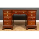 An early 20th century mahogany pedestal desk with nine drawers and bracket feet, 137cm wide x 60cm