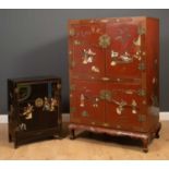 A Chinese red lacquered display or TV cabinet decorated with figures in architectural landscapes,
