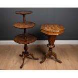 A Victorian walnut octagonal work table, with a marquetry inlaid chest board top and a tripd base,