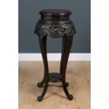 A Chinese stained wooden plant stand decorated with prunus blosson, 37cm diameter, 90cm high