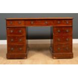 A late 19th / early 20th century mahogany pedestal desk with nine drawers having brass ring