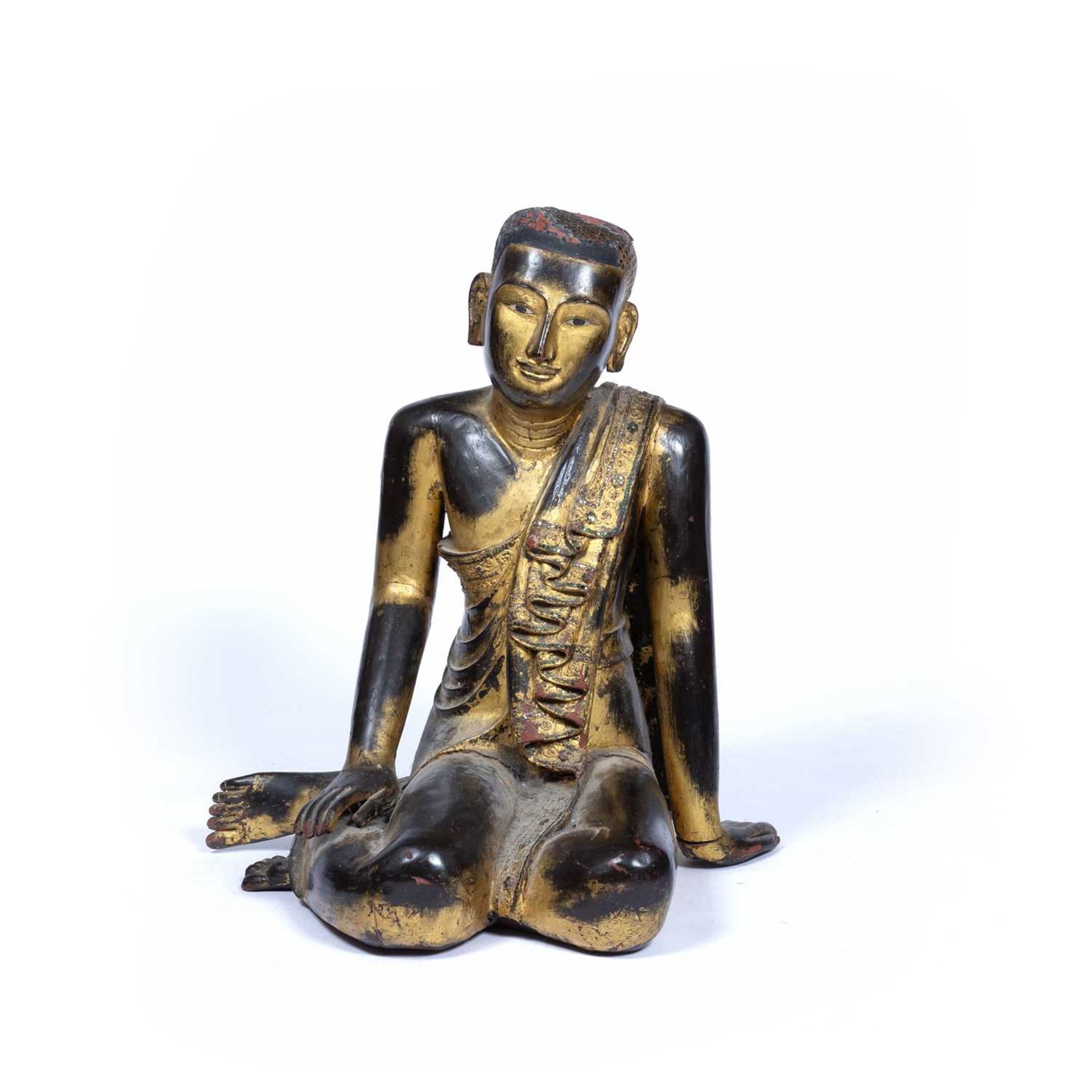 Wooden figure South East Asian, depicted seated with robes draped over one arm, with original traces