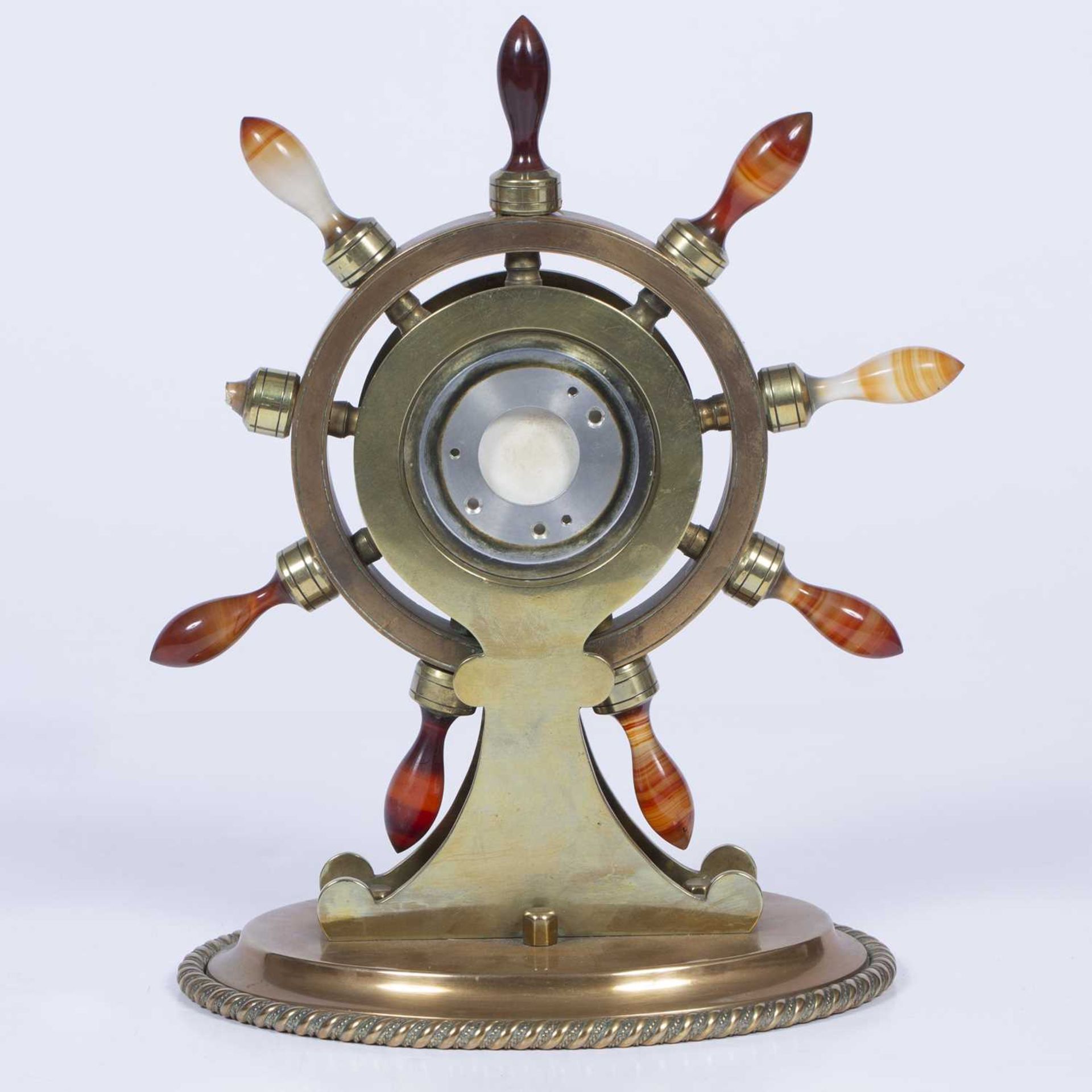 Brass and onyx ship's wheel model clock inset with blue enamel and on an oval base, with a later - Image 2 of 2