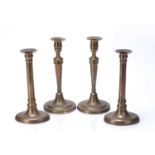 Two pairs of brass candle sticks one pair on a circular base, 25.5cm high, the other on navette