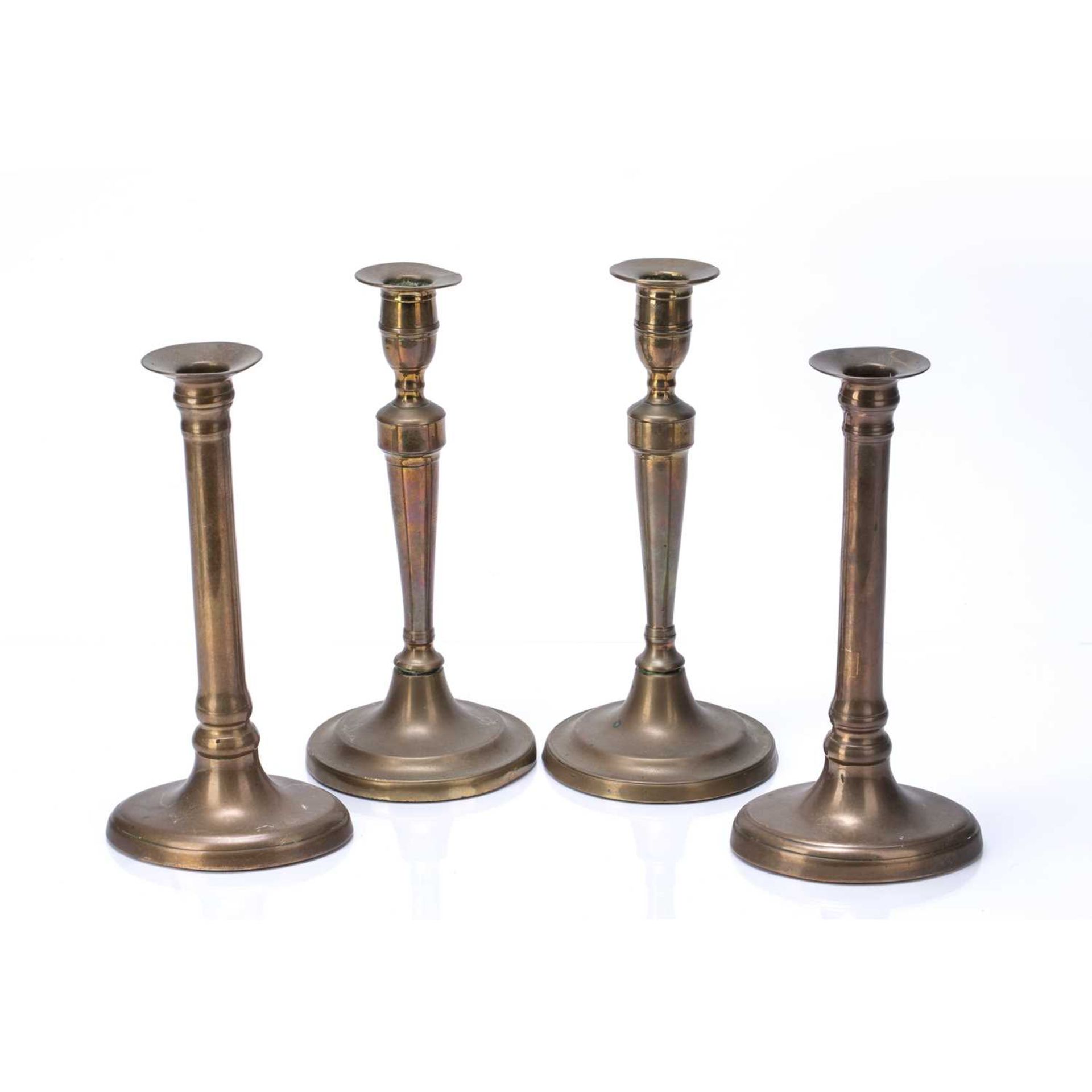 Two pairs of brass candle sticks one pair on a circular base, 25.5cm high, the other on navette