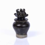 Black glazed jar and cover Chinese, with a brown/black glaze, the lid modelled as a pagoda, 12cm