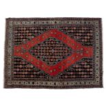Saveh red ground rug with central stylised panel and with foliate border, 188cm x 139cmSome light