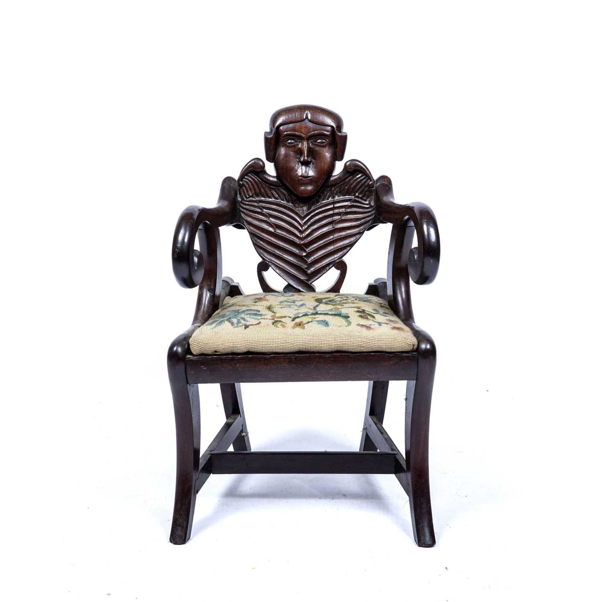 Carved childs chair with a skeleton back on sabre legs with a drop in seat, 64 cm high x 39cm