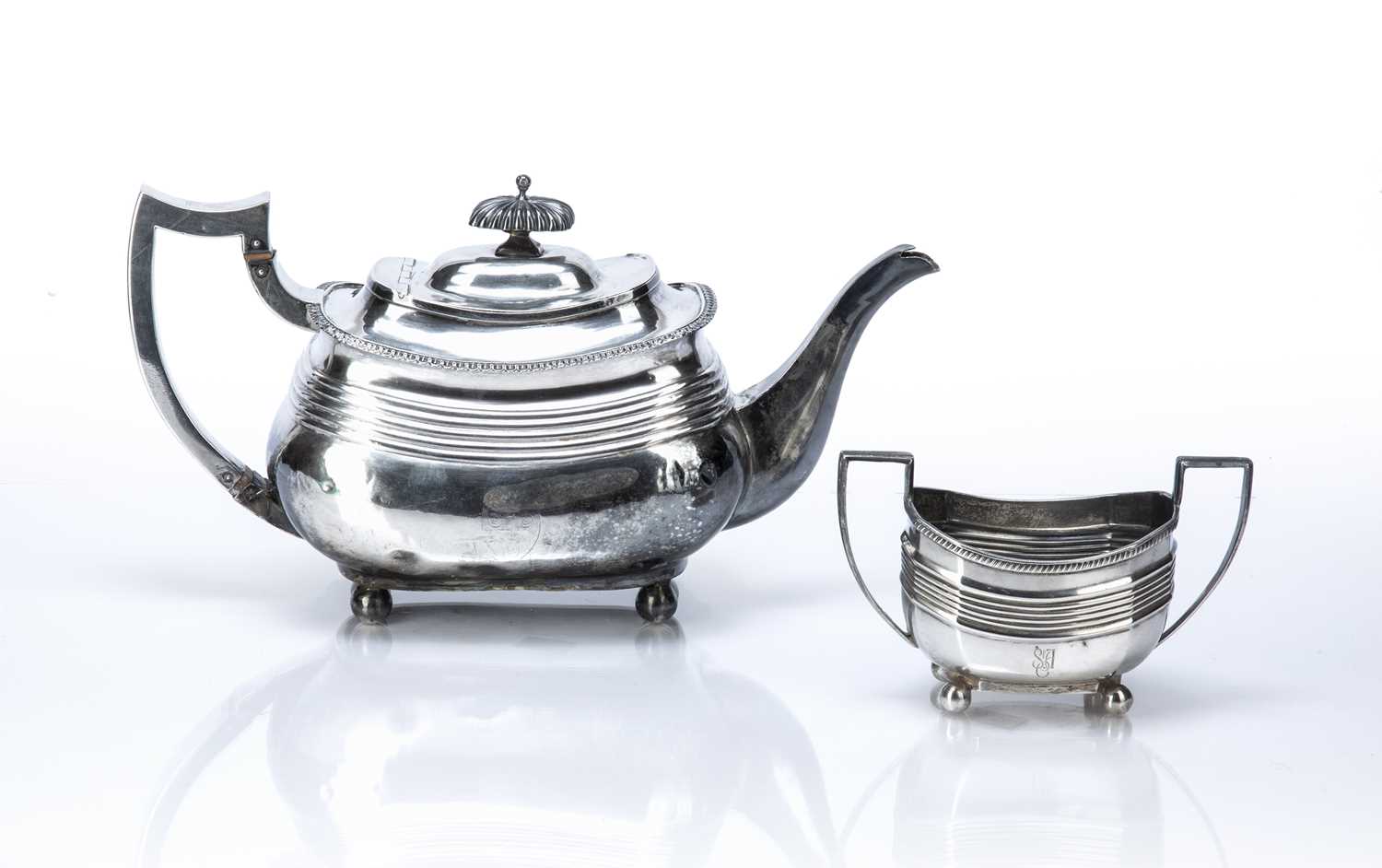 Georgian silver teapot and similar twin handled silver sucrier the teapot decorated with two