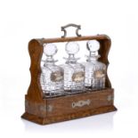 Oak cased tantalus fitted with three hobnail cut spirit decanters having silver spirit labels '