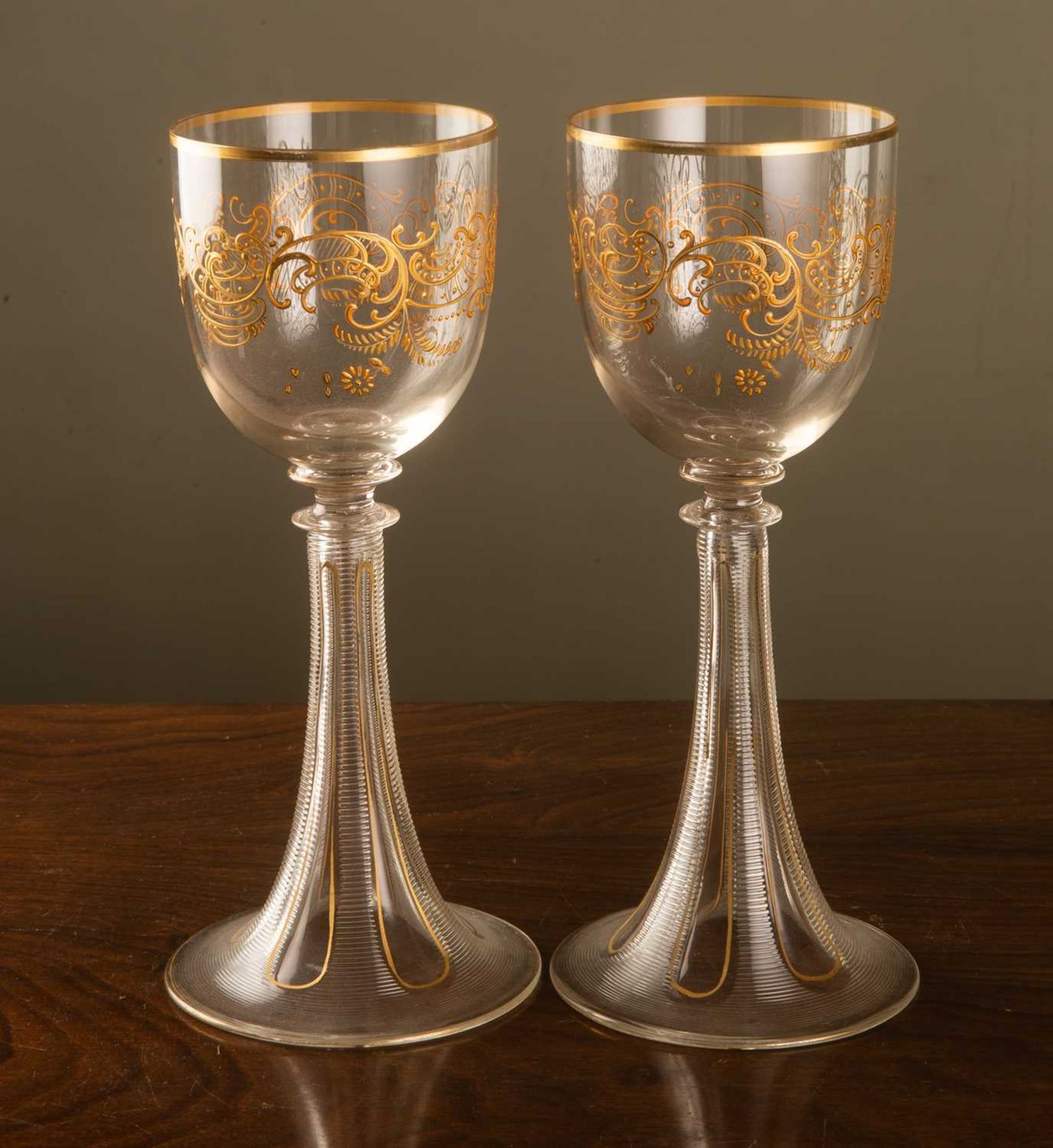 A pair of 19th century gilt decorated tall glasses with trumpet rimmed bases, 23cm high (2)Some