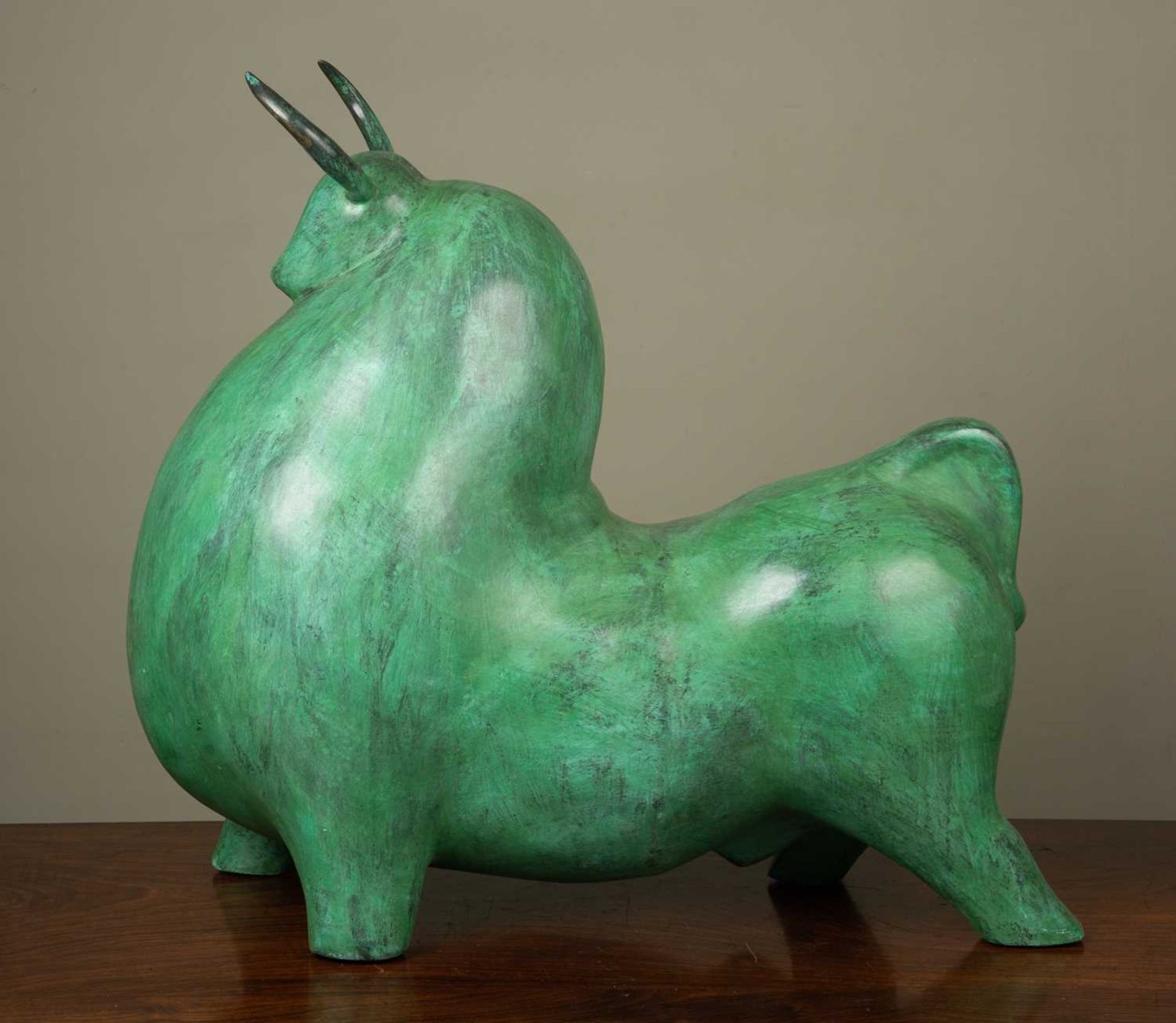 A 21st century school bronze sculpture in the form of bull with green patination, 60cm long, 55cm