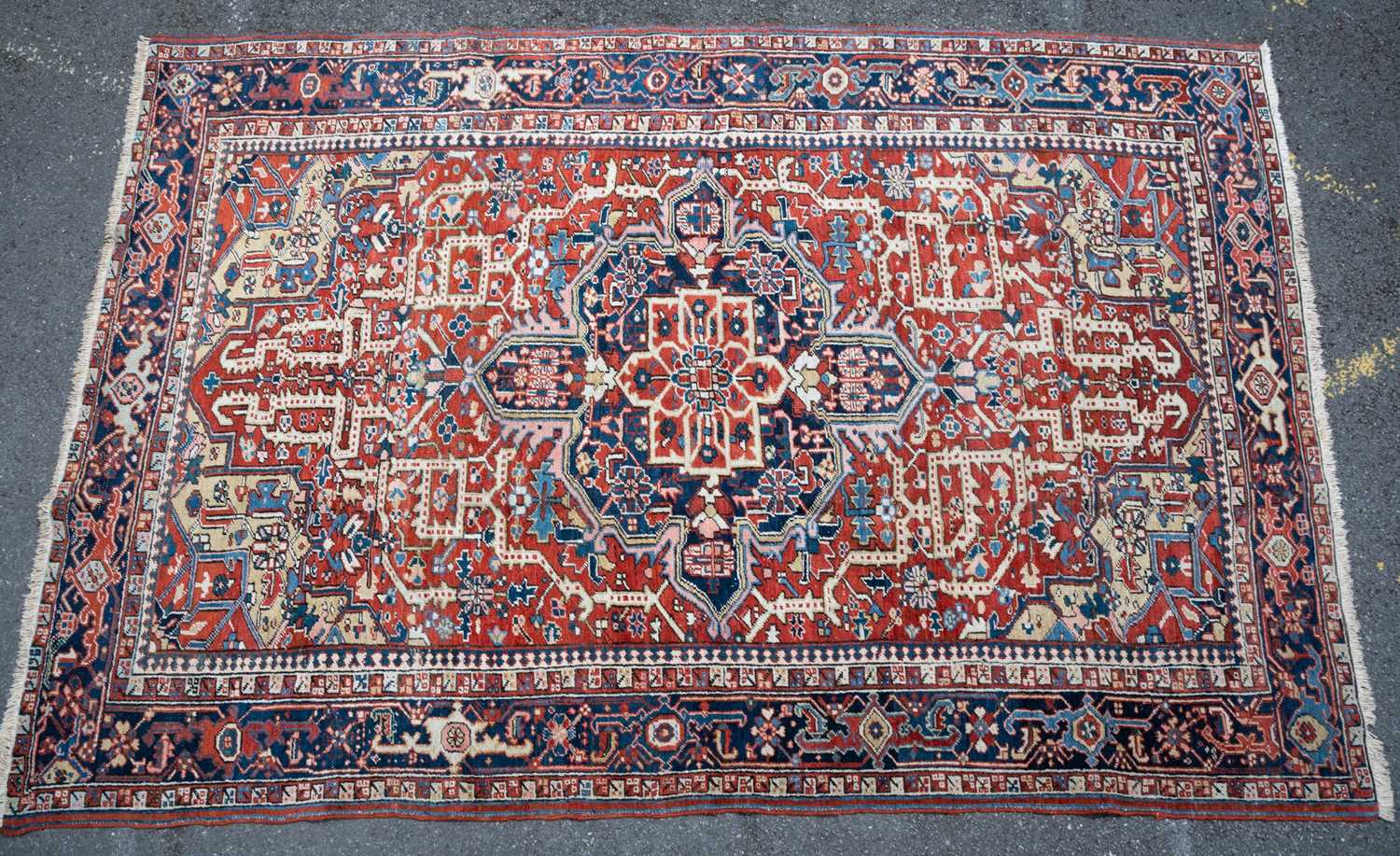 A red ground Heritz rug with geometric ornament to the central field and within a multiple banded