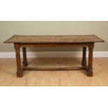 A 17th Century style oak refectory table, the plank top with cleated ends and on turned legs