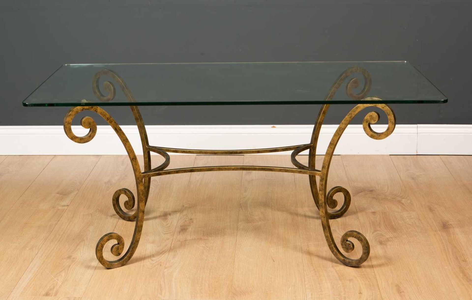 A coffee table by Tom Faulkner with painted scrolling wrought iron base and rectangular plate