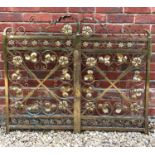 A pair of lacquered brass ornamental gates decorated with pressed leaves and flowers, possibly