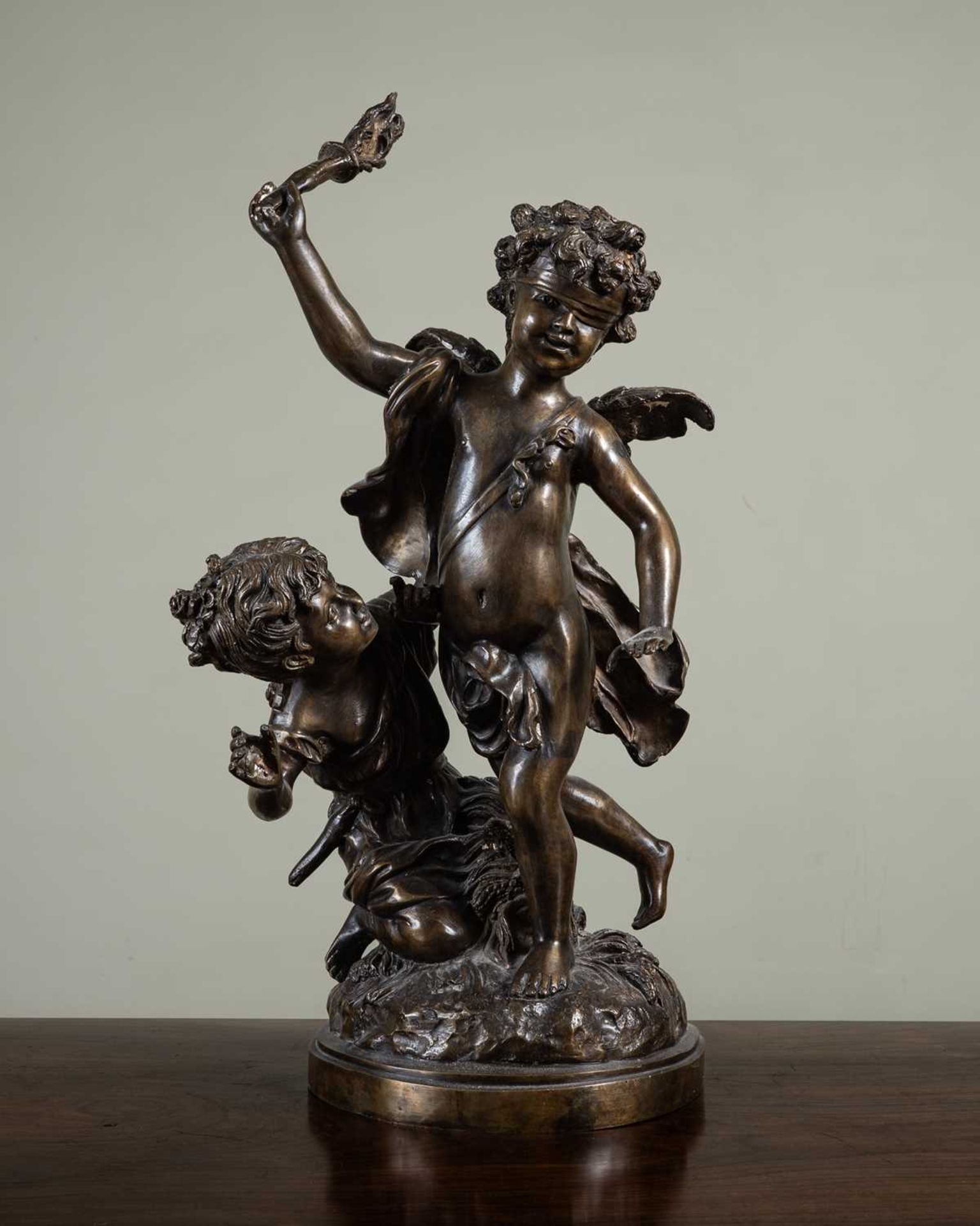 After Edme Bouchardon blindfolded cupid being teased by girl, bronze, on a circular plinth base,