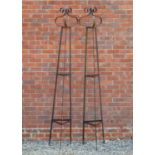 A pair of wrought iron spreading triangular section rose supports, with scrolling finials, each