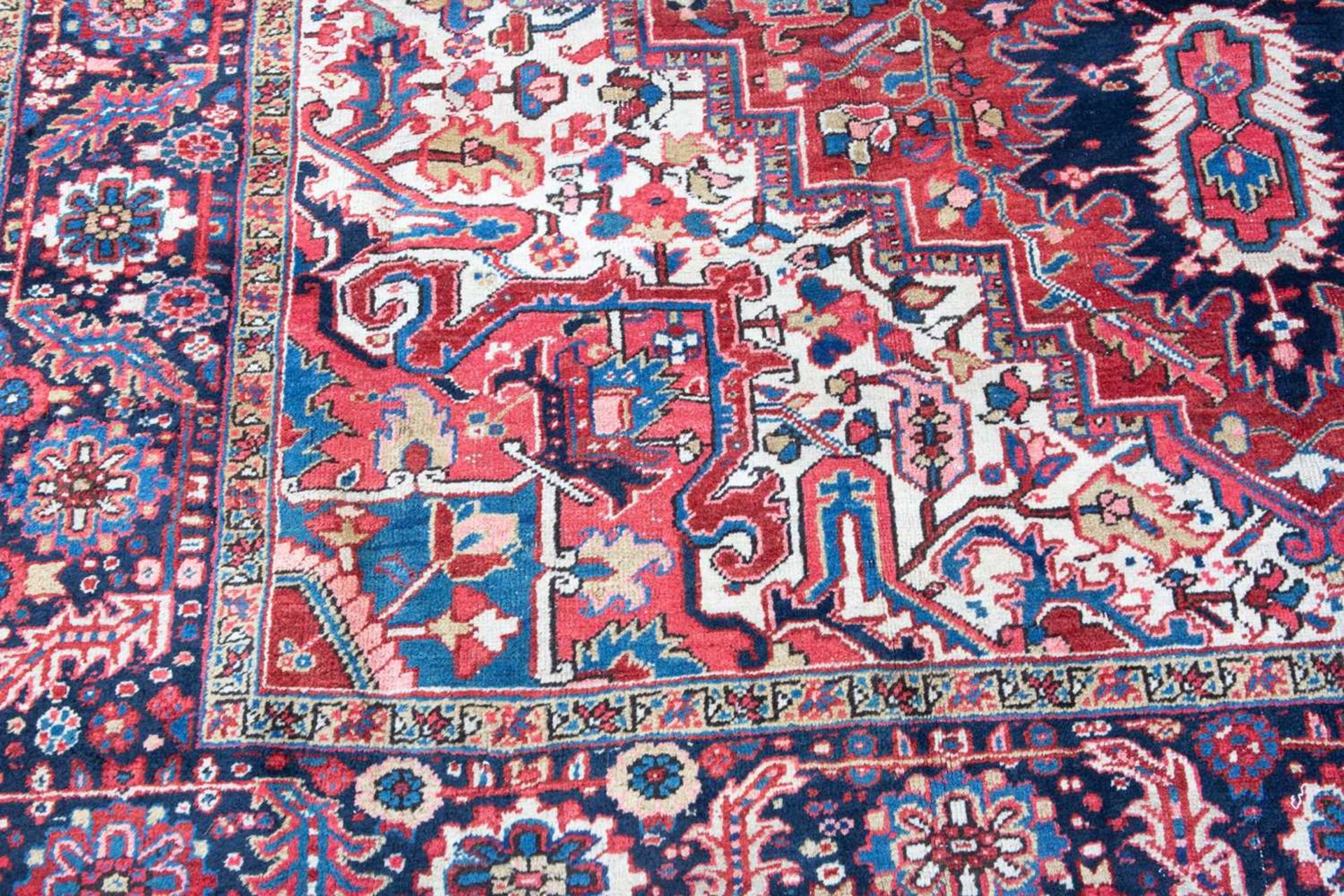 A Middle Eastern Heriz red and blue ground carpet the border with polychrome floral heads around a - Image 2 of 6