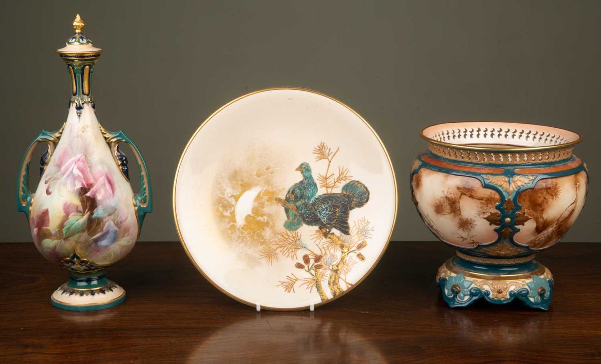 A Hadley's Worcester porcelain jardiniere with pierced rim and painted decoration of peacocks in