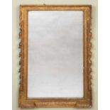 An antique wall mirror, the gilt frame with outset corners and husk swags, 64cm x 90cmSome minor