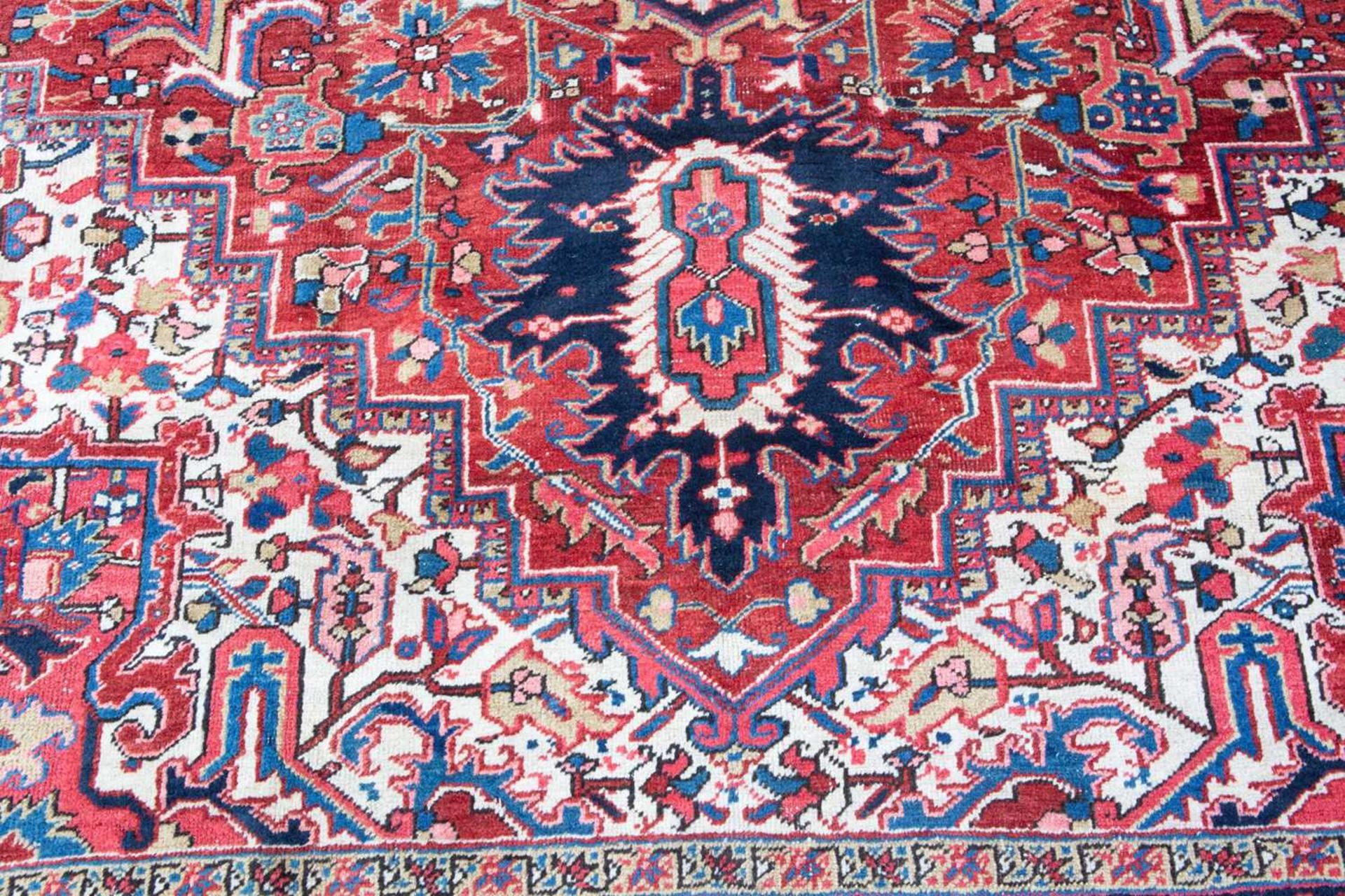 A Middle Eastern Heriz red and blue ground carpet the border with polychrome floral heads around a - Image 4 of 6