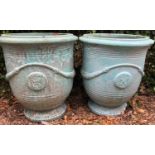 A pair of green glazed large garden planters with applied seal decoration, 67cm diameter x 75cm