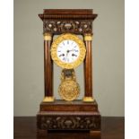 A French walnut portico clock with brass and mother of pearl decoration, the white enamel dial