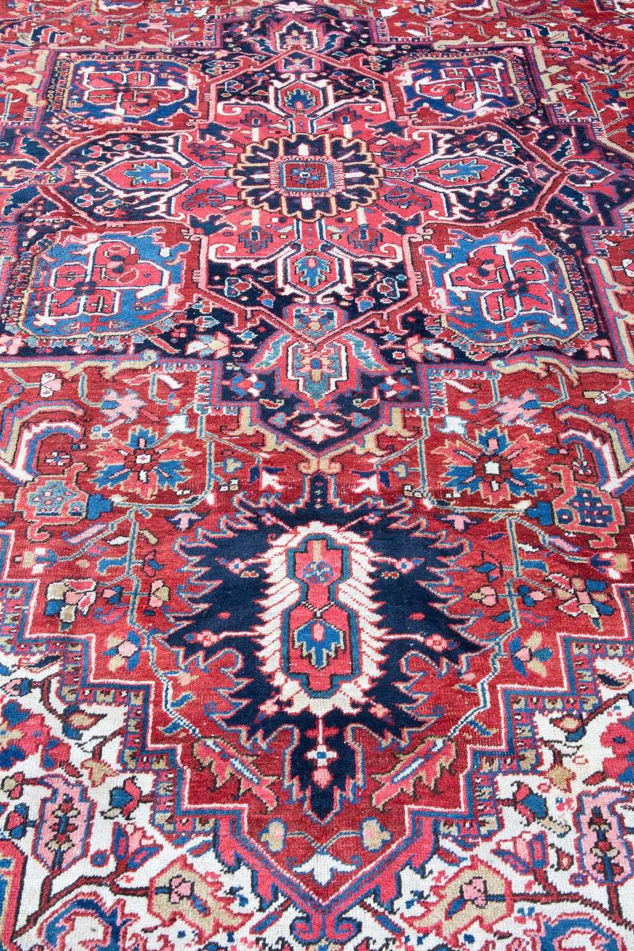 A Middle Eastern Heriz red and blue ground carpet the border with polychrome floral heads around a - Image 3 of 6
