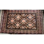 A brown ground Tribal rug with central stylised diamond motifs within a banded border, 188cm x