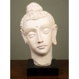 A V&A reproduction stone Indian head, stamped 'V&A Austin, 1995', on black plinth base, 46cm high