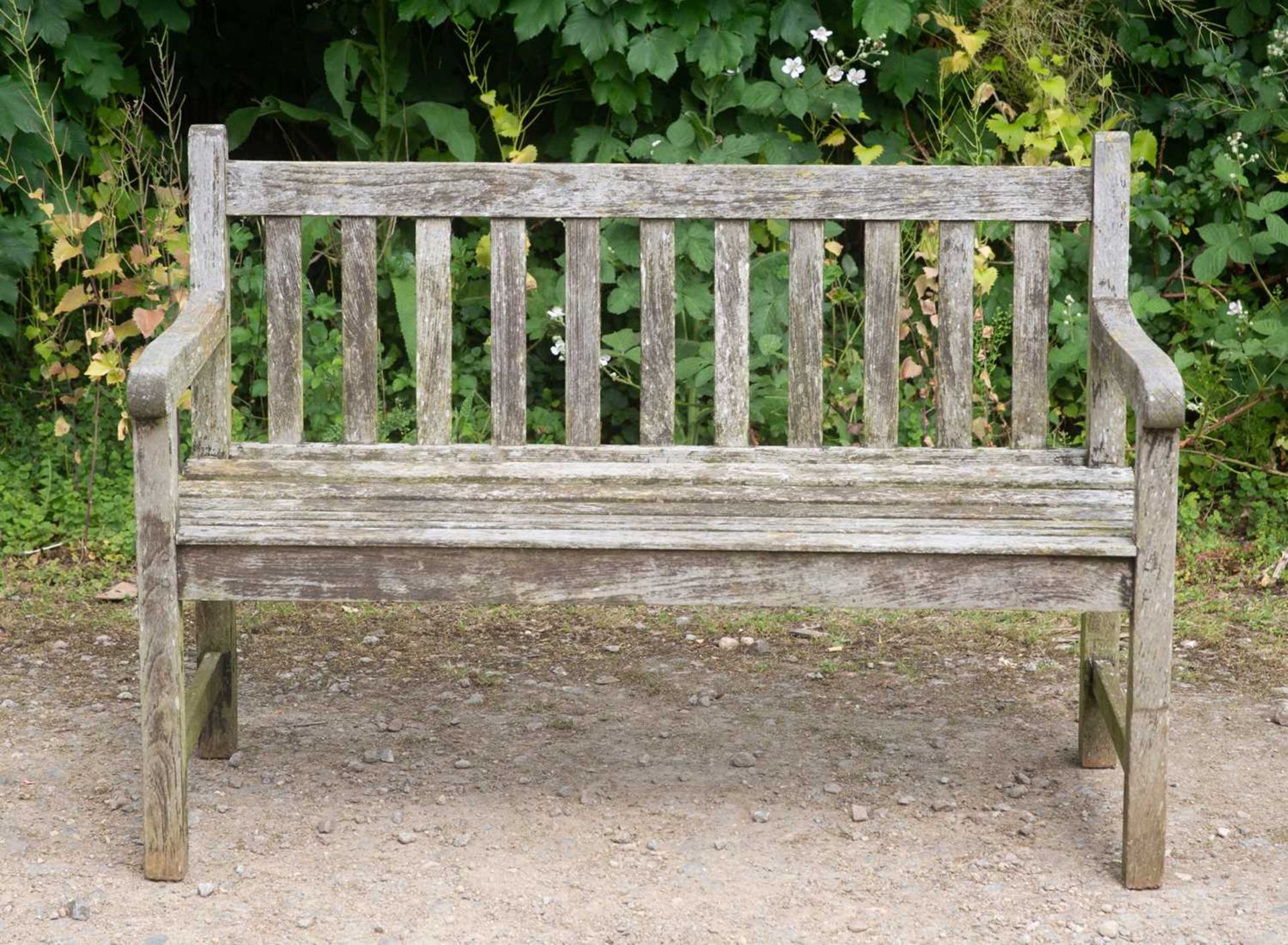 A small teak garden bench with slatted back and seat, 121.5cm wide, 55cm deep, 84cm highWeathered
