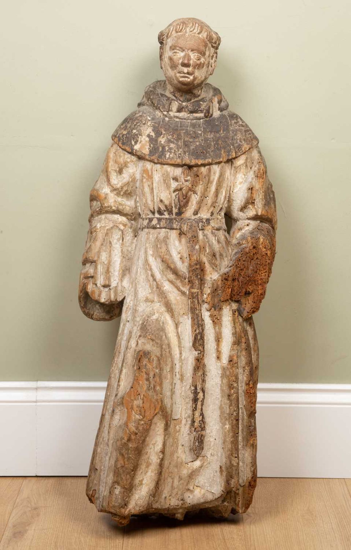An antique, possibly 17th century, continental carved pine sculpture depicting a monk dressed in his