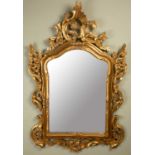 A modern gilt wall mirror, with scrolling floral and foliate decoration and shaped mirror plate,