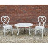 A pair of white painted cast aluminium garden chairs with shaped backs, lattice work seats and