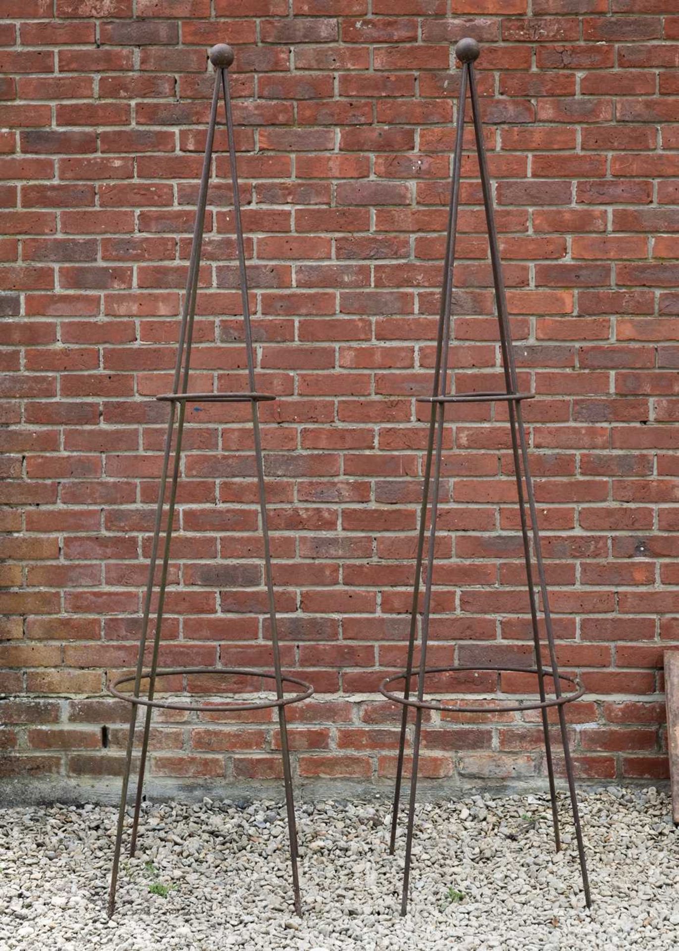 A pair of wrought iron conical garden rose supports, both with a ball finial, standing 206cm