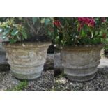 A pair of cast reconstituted stone garden urns, relief decorated with ribbon tied swags, 77cm