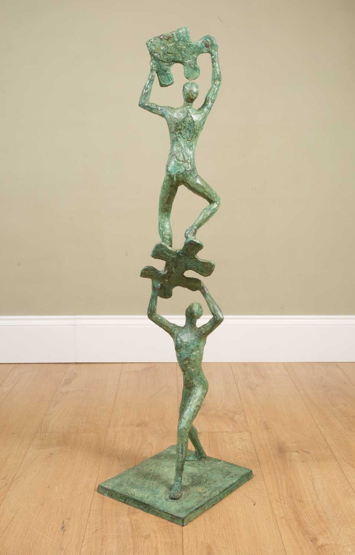 A 21st century school sculpture of a bronze with two figures climbing and supporting jigsaw