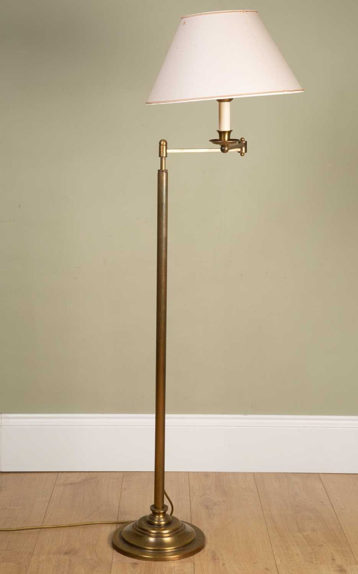 A contemporary brass floor standing adjustable reading lamp, on circular spreading base, the base