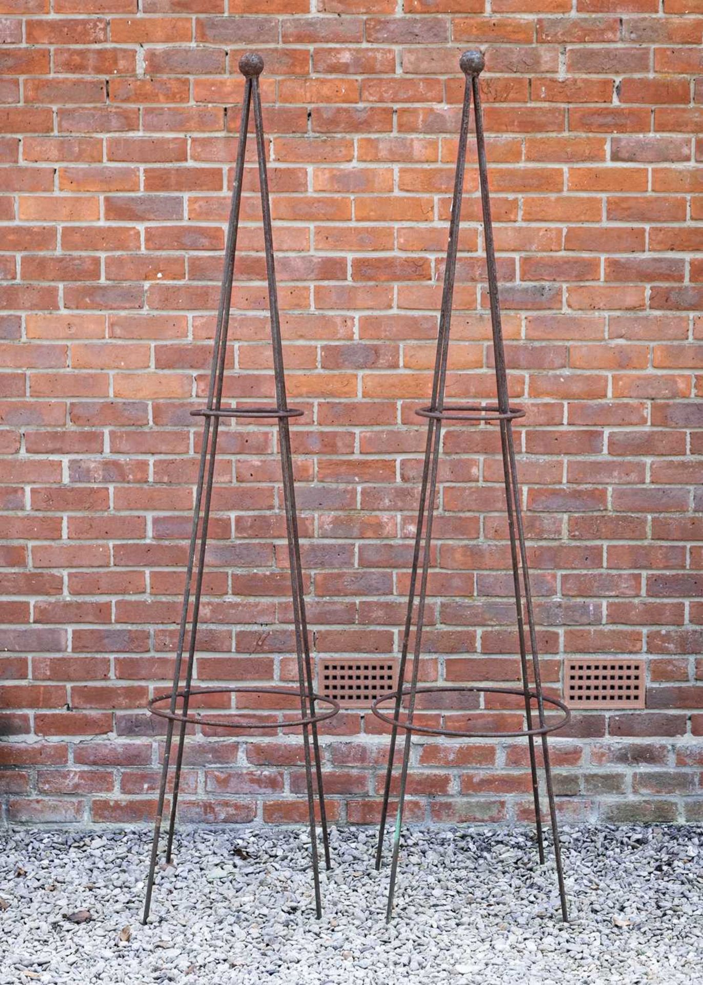 A pair of wrought iron conical garden rose supports, both with a ball finial, standing 206cm