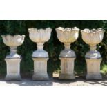 A set of three cast reconstituted stone garden urns decorated with acanthus leaves on octagonal