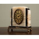 An early 20th century Art Deco timepiece, with stepped onyx and marble case, with an oval dial, with