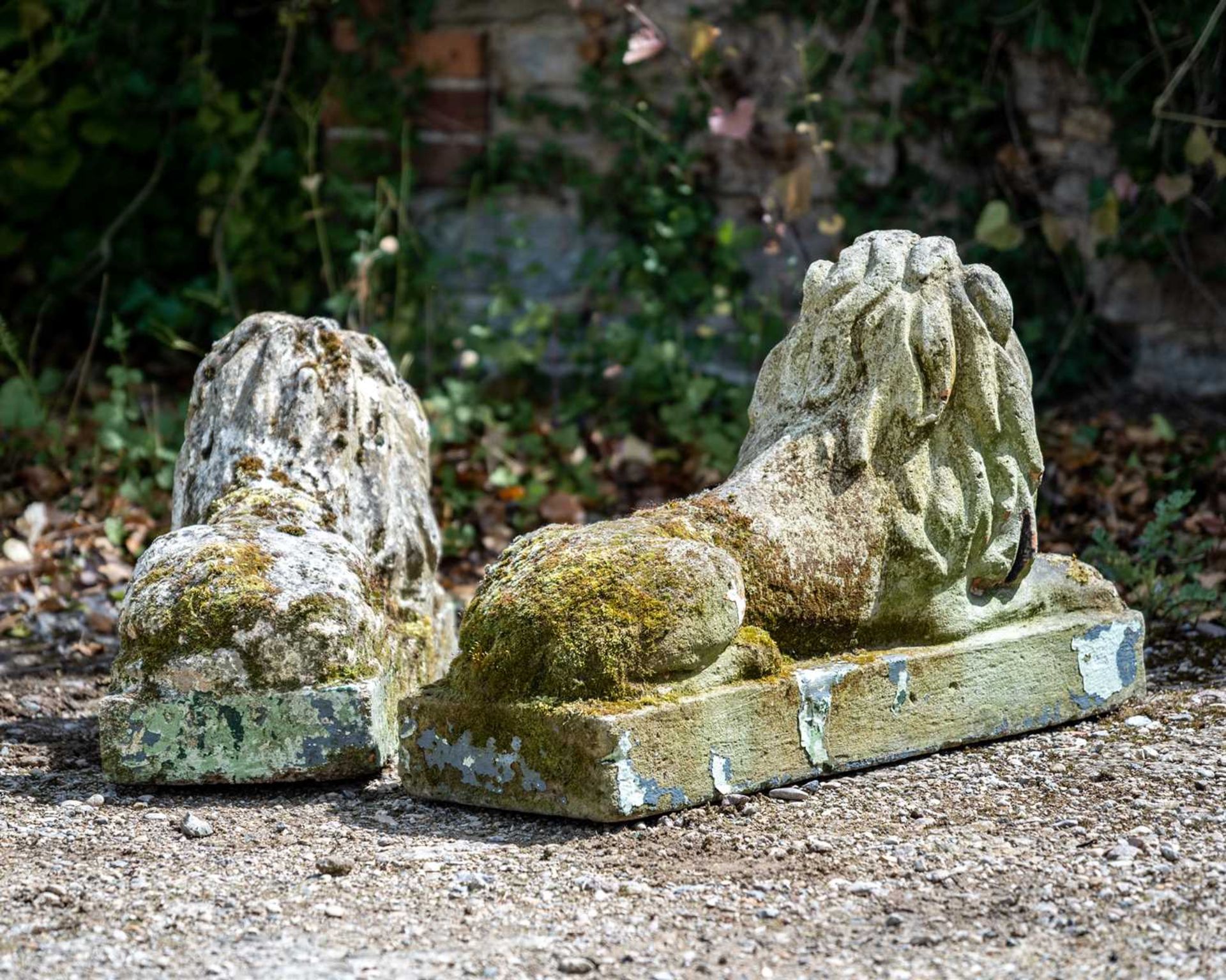 A pair of old cast reconstituted stone reclining lions, each with glass eyes, 72cm long x 23cm - Image 2 of 2