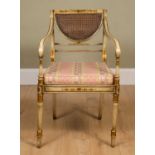 A Regency-style painted elbow chair, with caned back and seat, squab cushion, all standing on turned