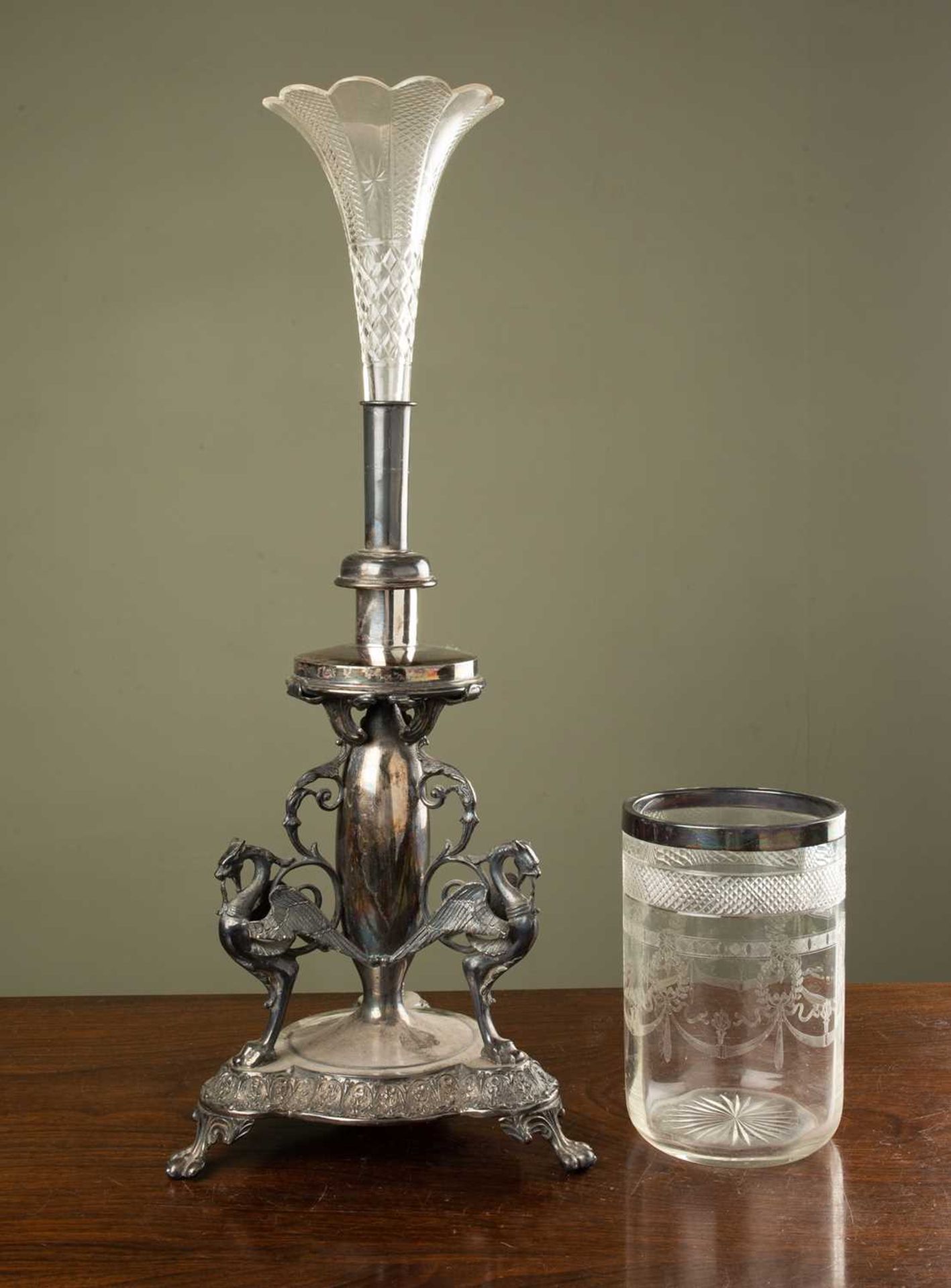 A silver plated and cut glass centre piece, the cut glass crystal top on tripod base with winged